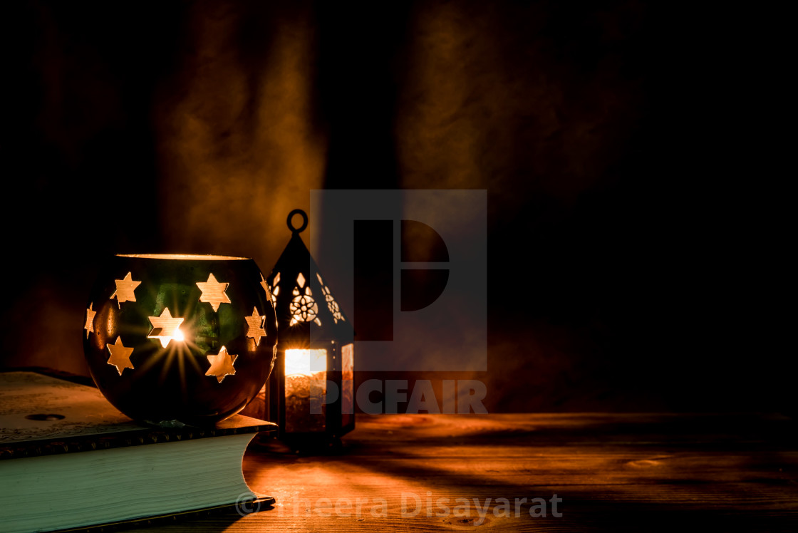 Arabic lantern with candle at night for Islamic holiday. Muslim holy month  Ramadan. The end of Eid and Happy New Year. Copy space on dark background.  - License, download or print for £