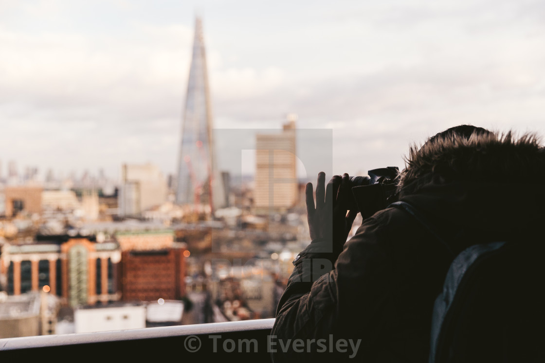 "Man taking photo with camera of modern London winter skyline" stock image