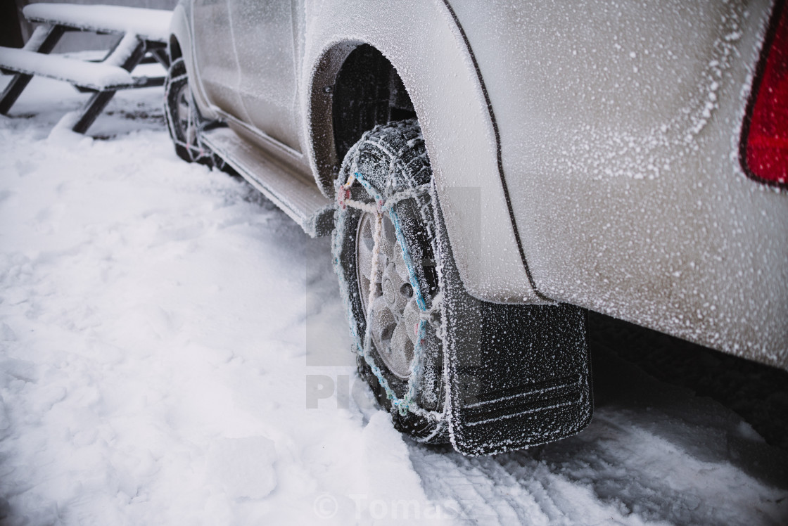 Close Up On Car Wheel With Snow Chains Winter Background