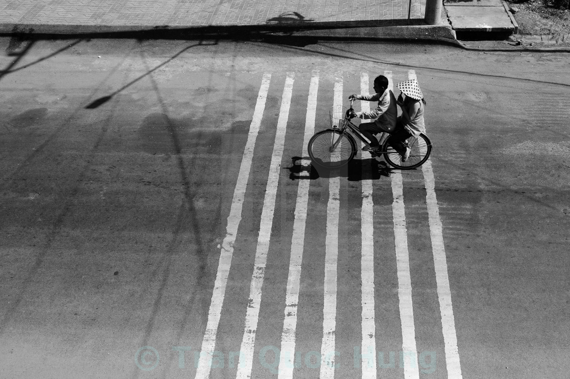 "A couple on a bicycle in strong sunlight" stock image