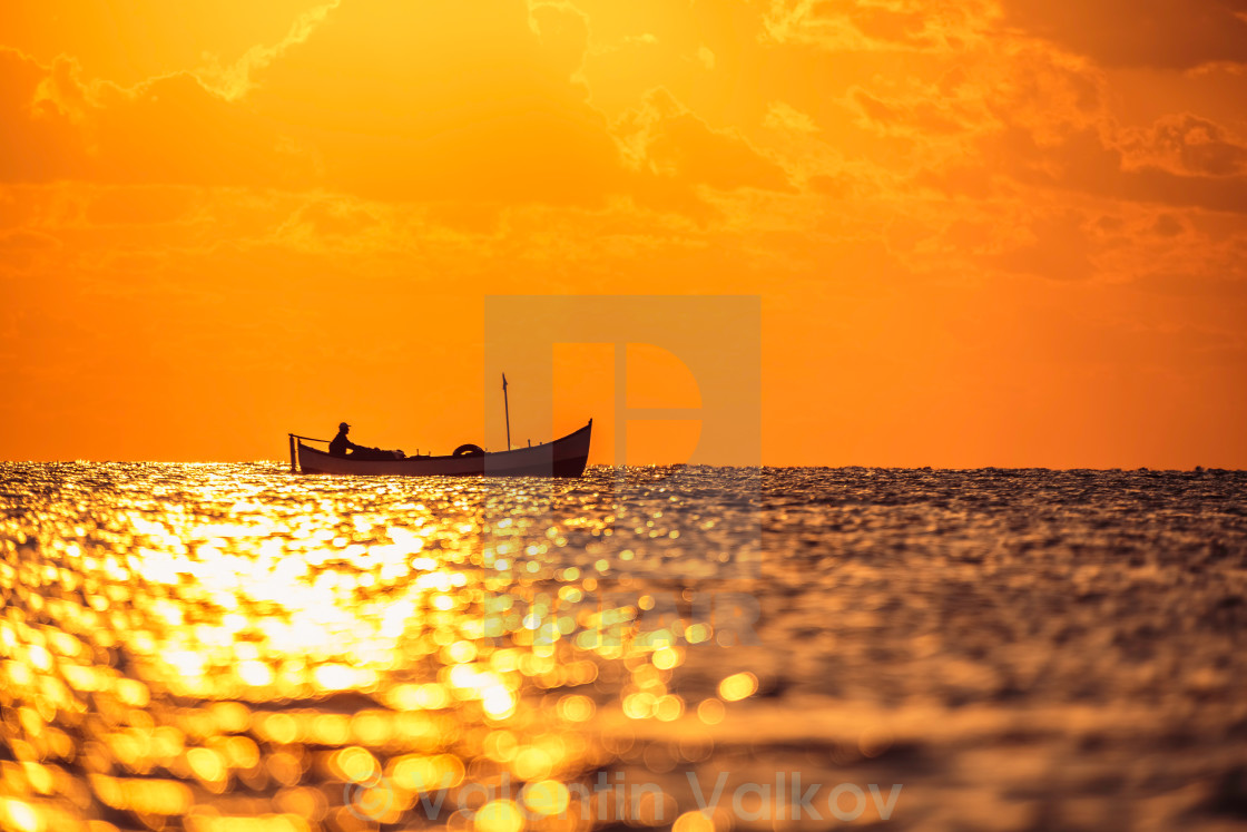"Fisherman sailling with his boat on beautiful sunrise over the sea" stock image