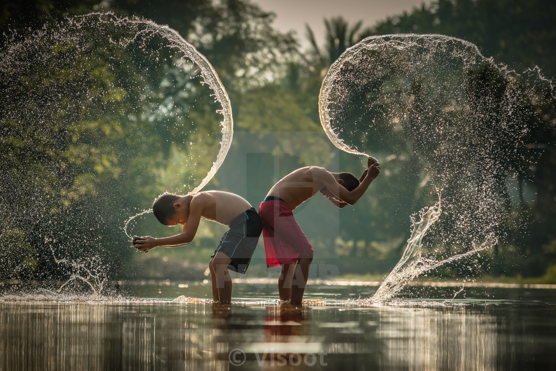 "Children playing splashing water in the river." stock image