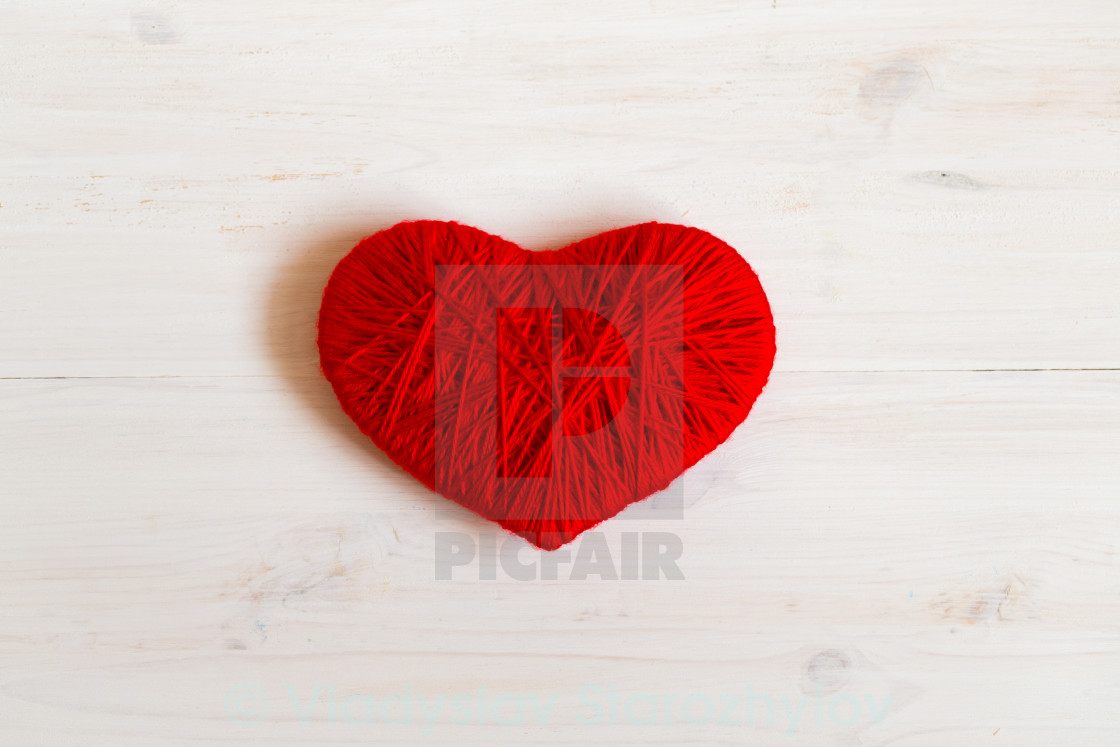 Red Heart Shape Made From Wool On White Wooden Background