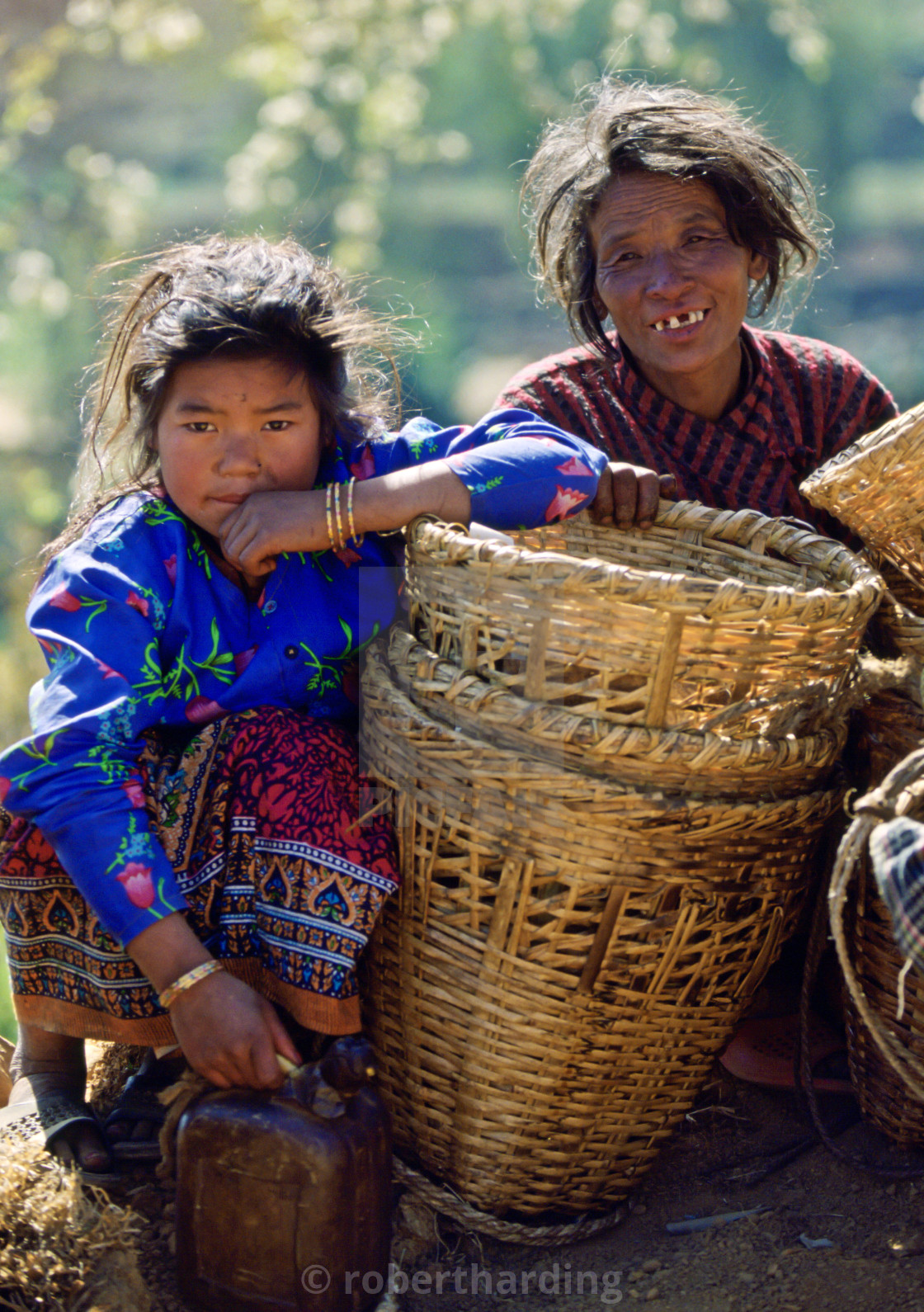 "A mother & daughter awaiting a bus to take them to the local market , Nepal" stock image