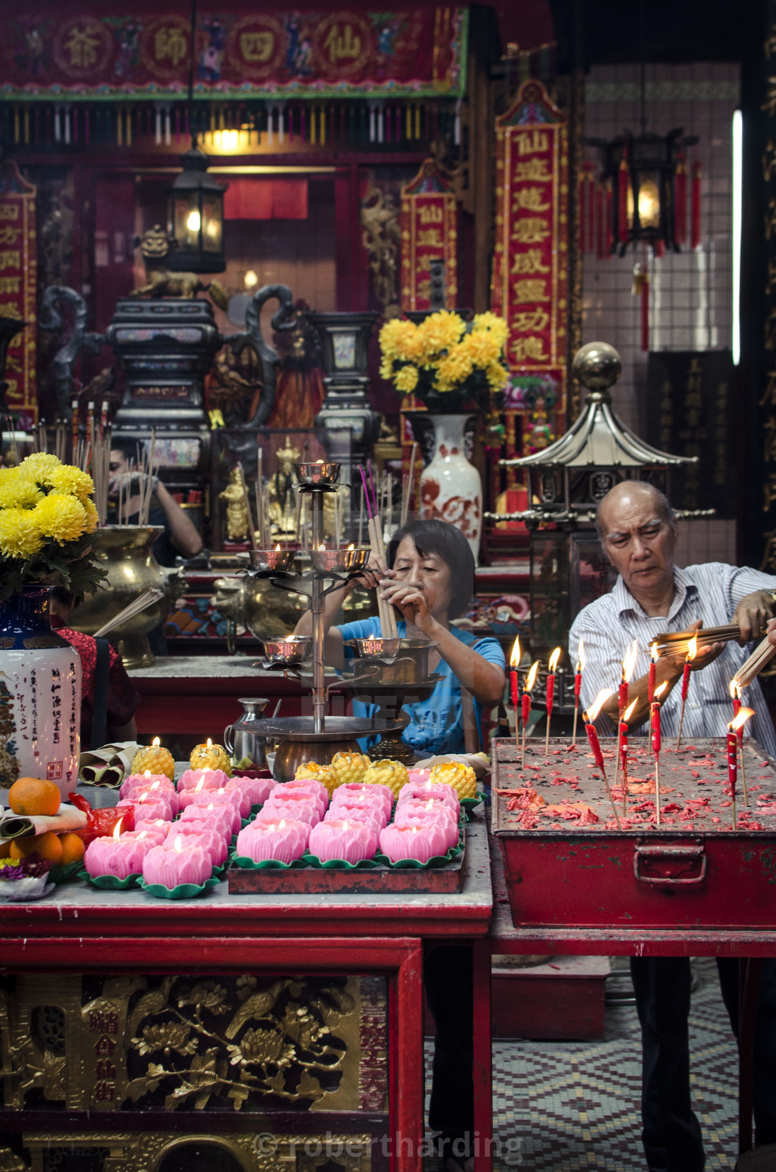 "A man and women light incense sticks during Chinese New Year celebrations,..." stock image