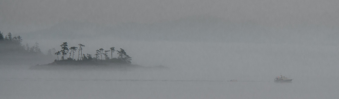 "Alaska shoreline in the fog with a boat" stock image