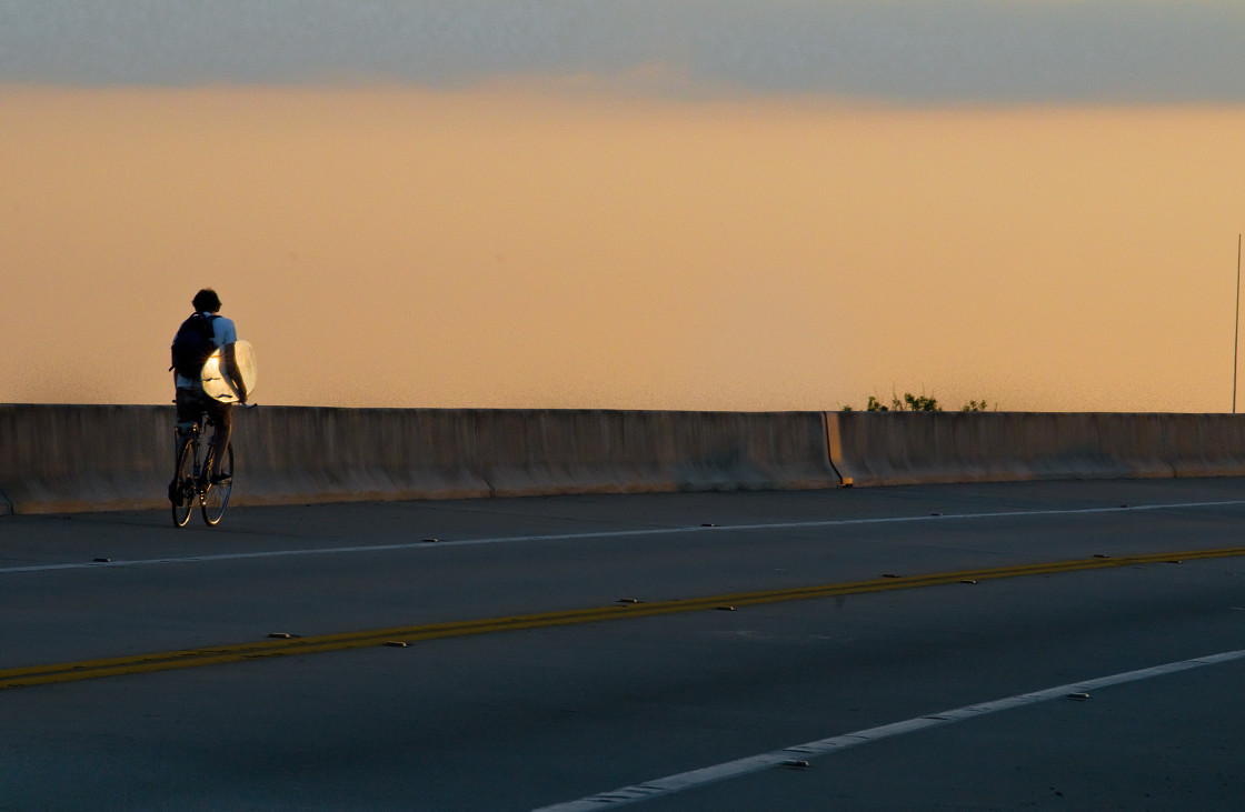 "Surfer heading out on a bike" stock image