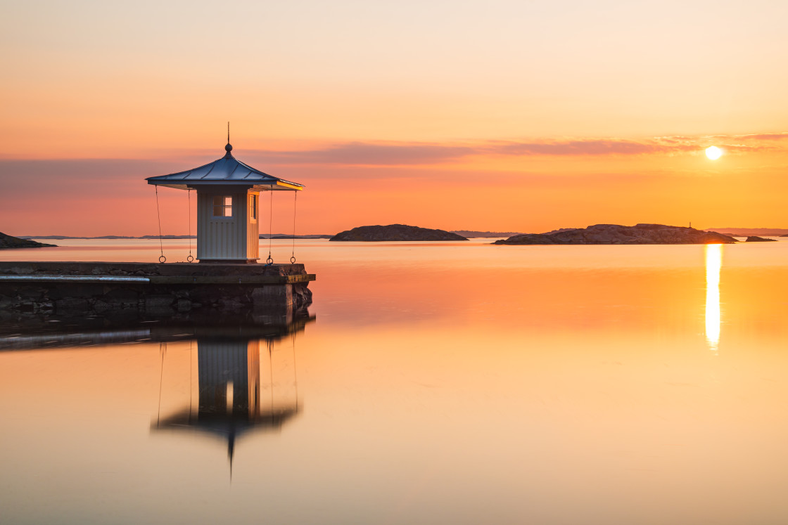 "Reflection of pier on idyllic sea during sunset" stock image