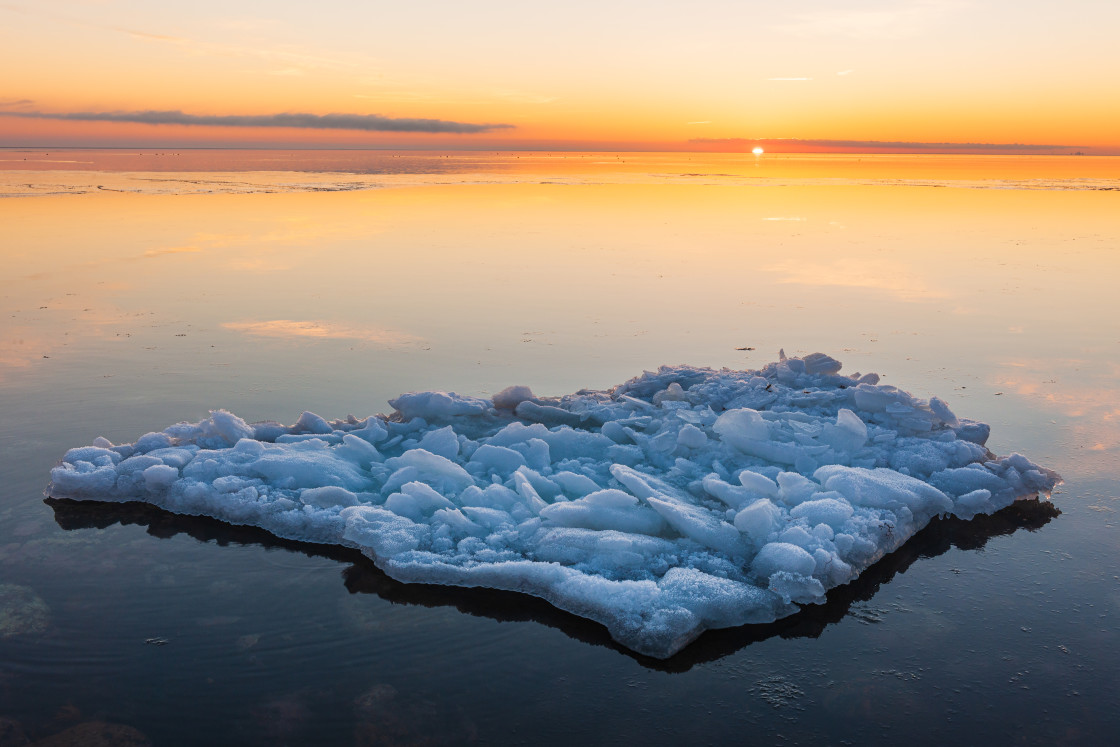 "Ice floating in sunlit water at sunset" stock image