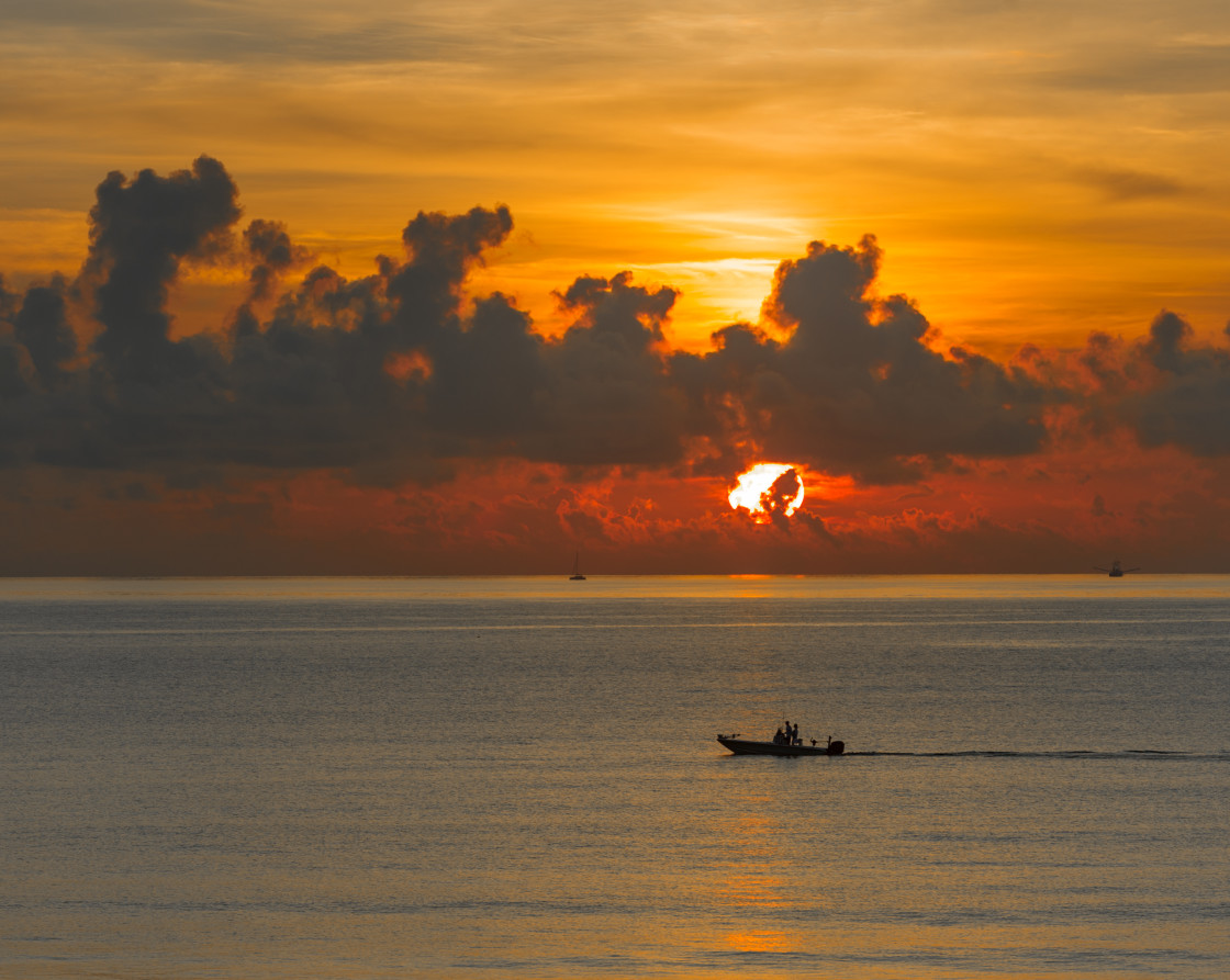 "Fishing boat at sunrise on the ocean." stock image