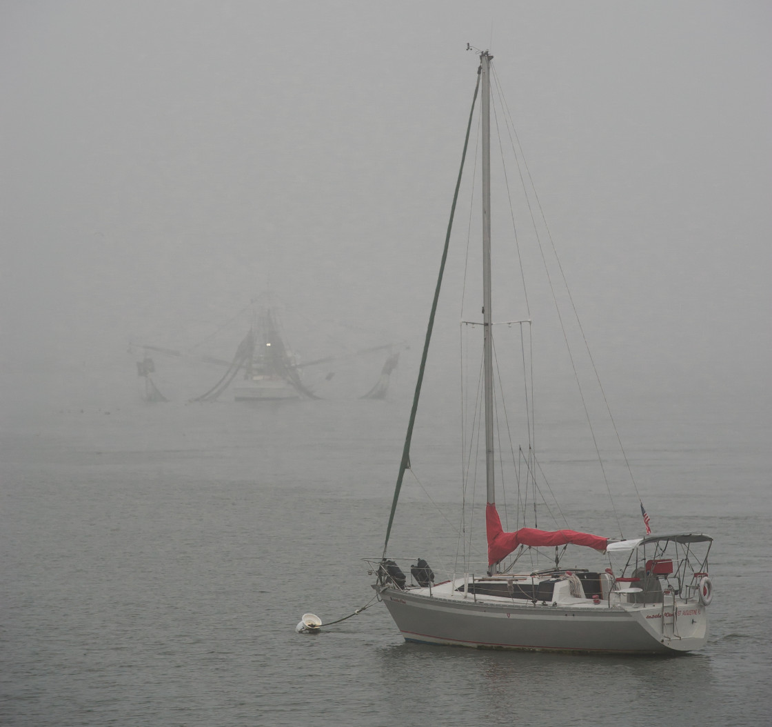 "Sailboat anchored in the fog" stock image