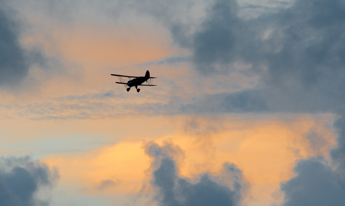 "Biplane silhouette at sunset" stock image