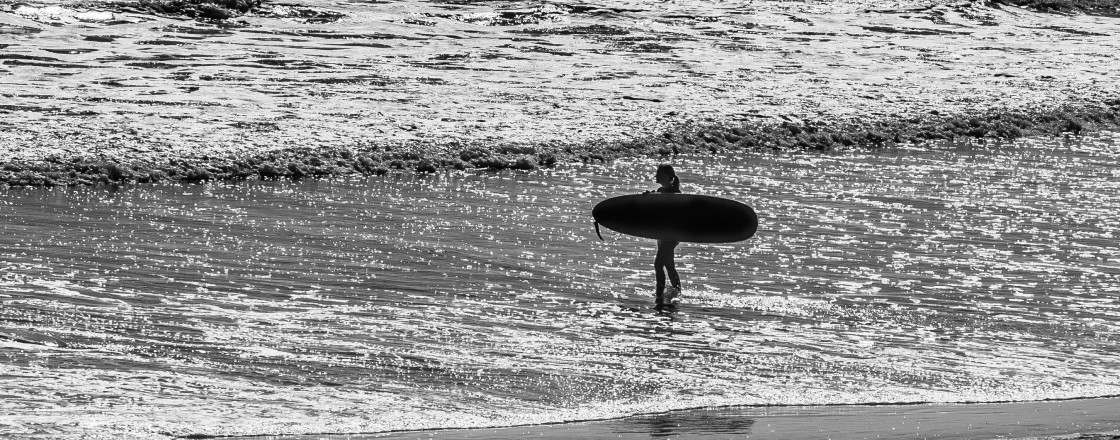 "Beach scene in black and white -sailboat and surfer" stock image