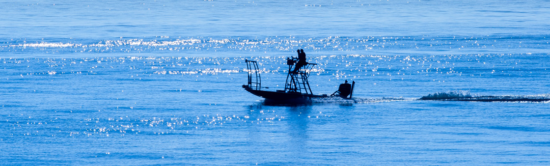 "Fishing boat at sunrise on the ocean." stock image