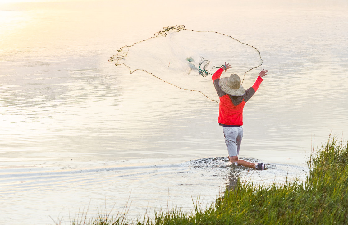 "Fisherman catching bait along the shore" stock image