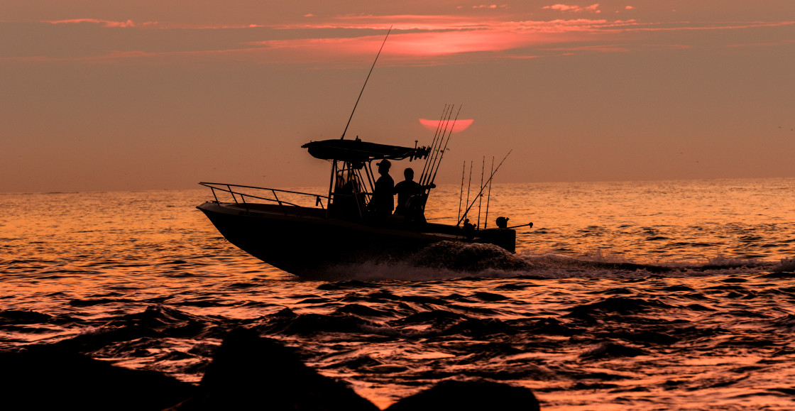 "Fishing boat at sunrise on the ocean" stock image