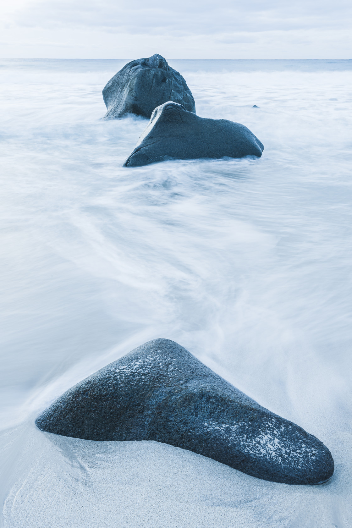 "Boulders on a sandy beach" stock image