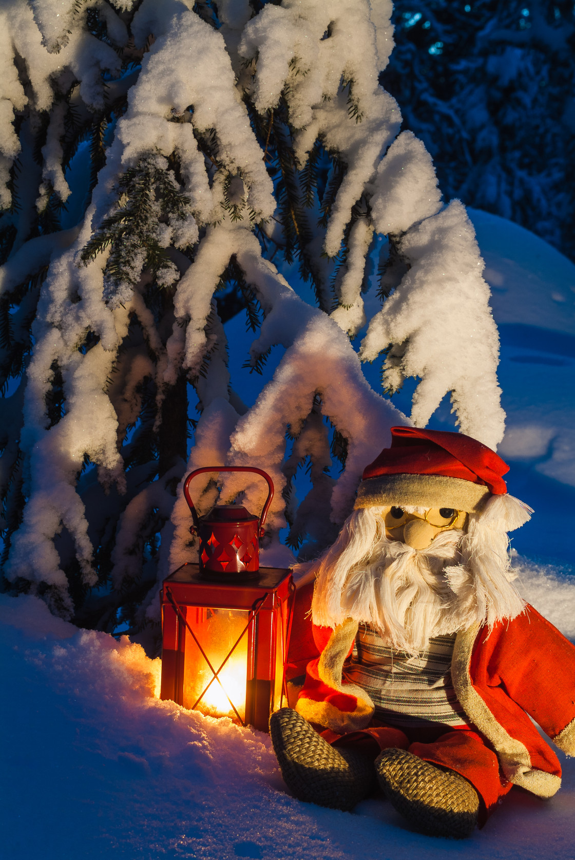 "Father Christmas doll sitting in snow covered forest" stock image