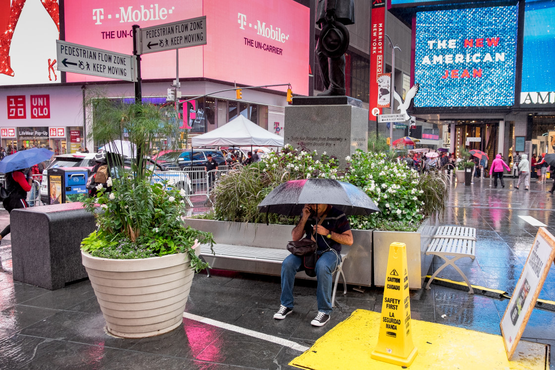 "Man on mobile phone under umbrella, Times Square." stock image