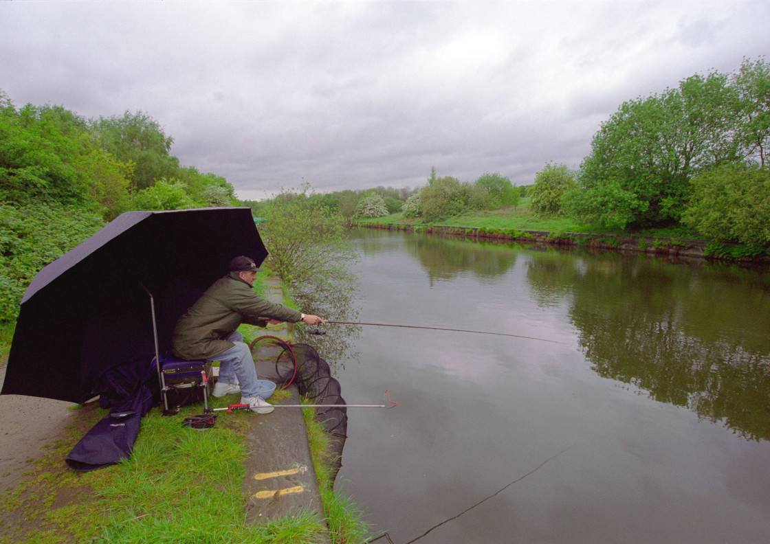 "Man fishing on canal" stock image