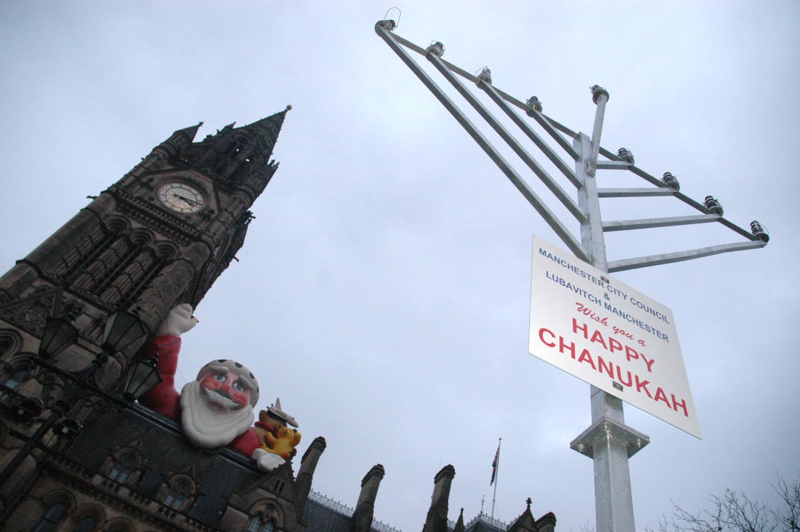 "Inflatable Santa looks down on Menorah" stock image