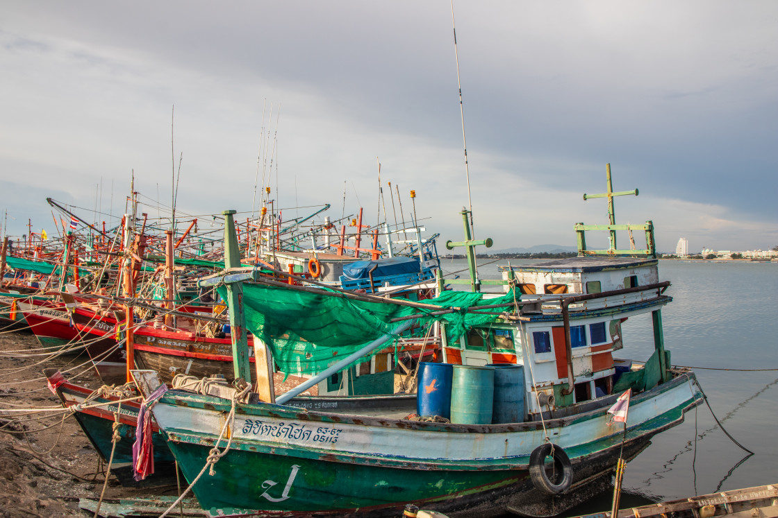 "Thai fishing boats at a pier or wharf in Thailand Southeast Asia" stock image