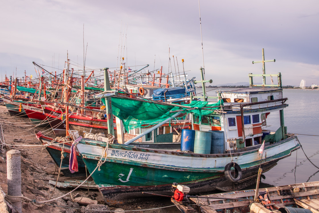 "Thai fishing boats at a pier or wharf in Thailand Southeast Asia" stock image