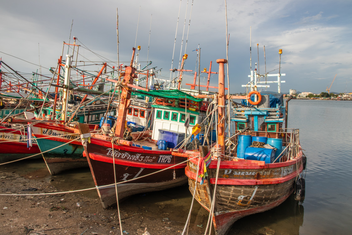 "Thai fishing boats at a pier or wharf in Thailand Southeast Asia" stock image