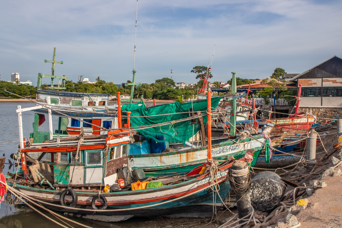 "Thai fishing boats at a pier or wharf in Thailand Southeast Asia" stock image