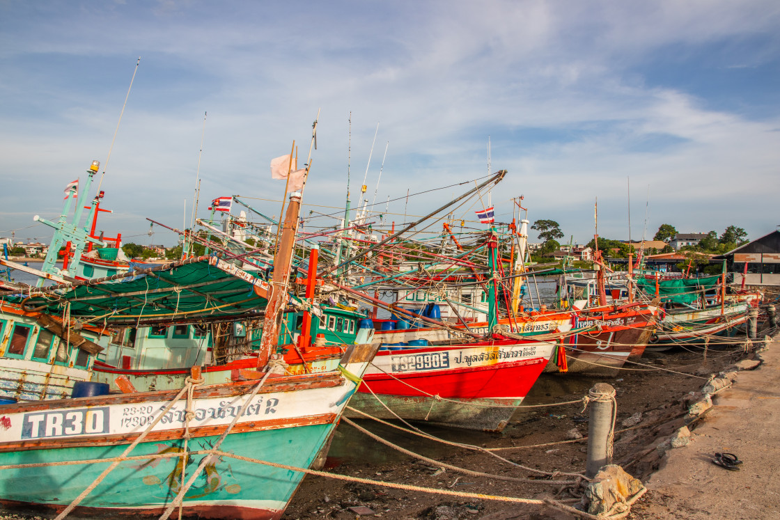 "Thai fishing boats at a pier or wharf in Thailand Southeast Asia" stock image