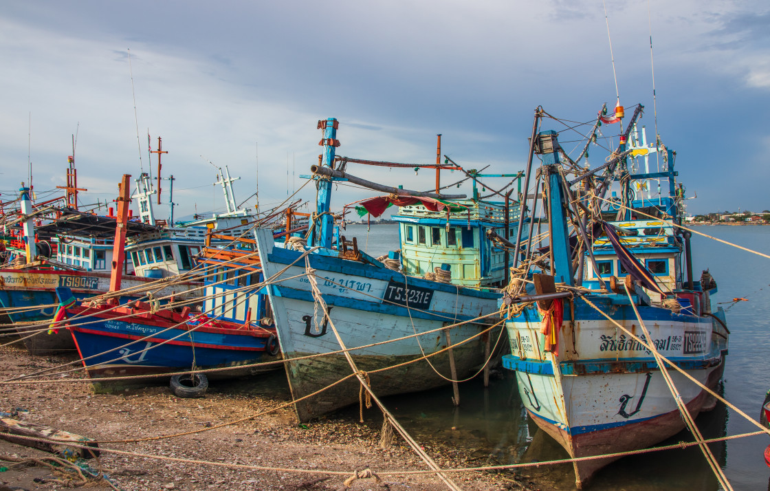 "Thai fishing boats at a pier or wharf in Thailand Southeast Asia" stock image