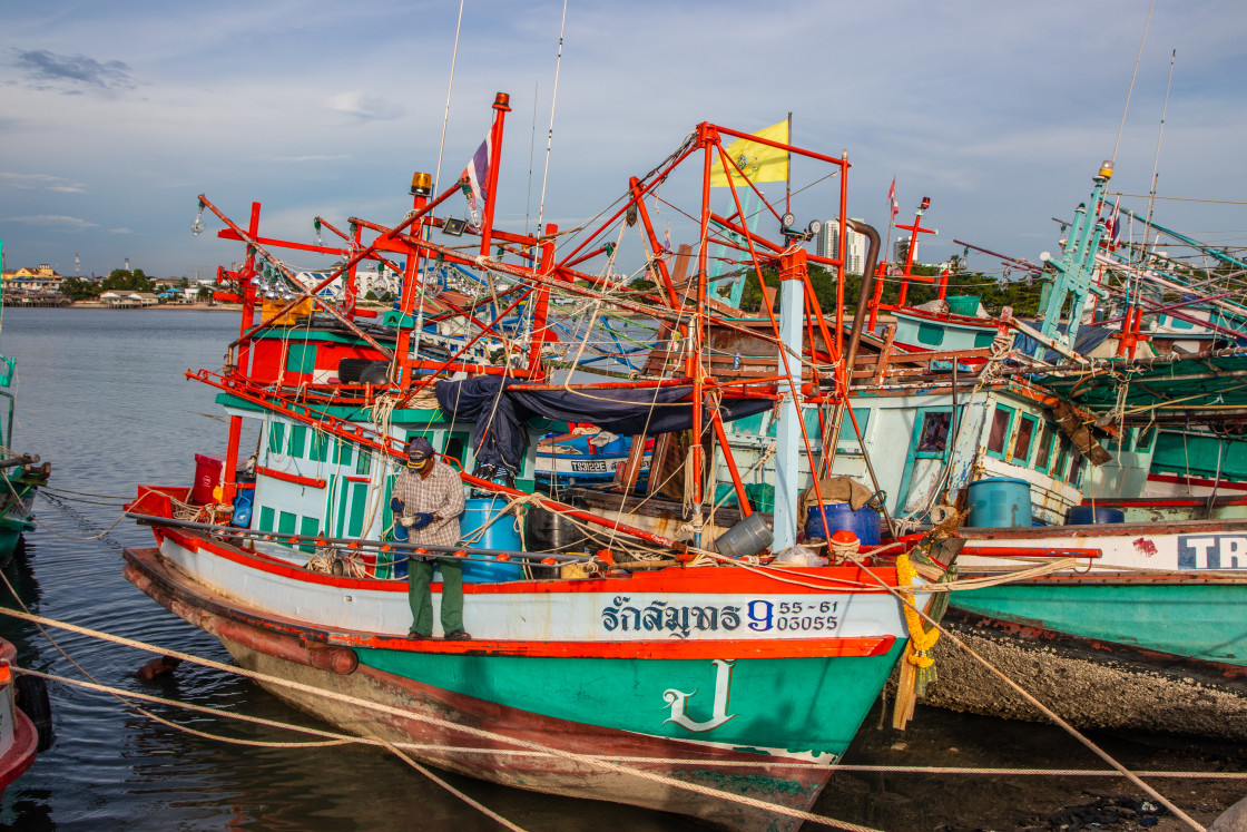 "Thai fishing boats at a pier or wharf in Thailand Southeast Asia" stock image