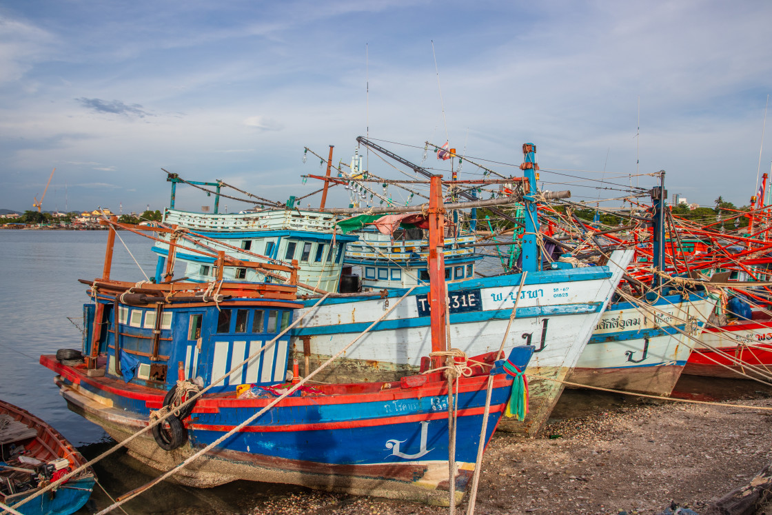 "Thai fishing boats at a pier or wharf in Thailand Southeast Asia" stock image