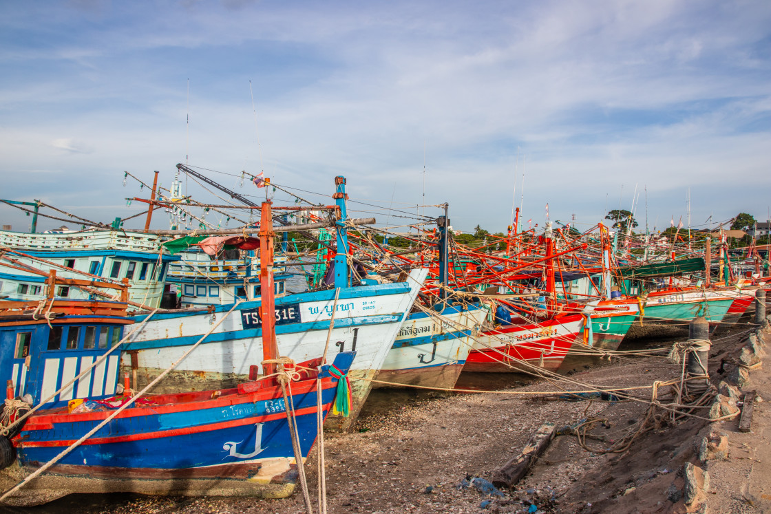 "Thai fishing boats at a pier or wharf in Thailand Southeast Asia" stock image