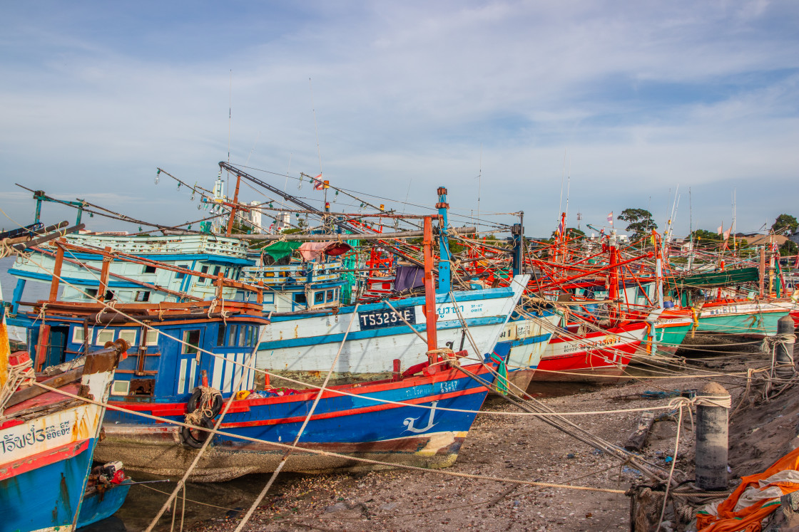 "Thai fishing boats at a pier or wharf in Thailand Southeast Asia" stock image