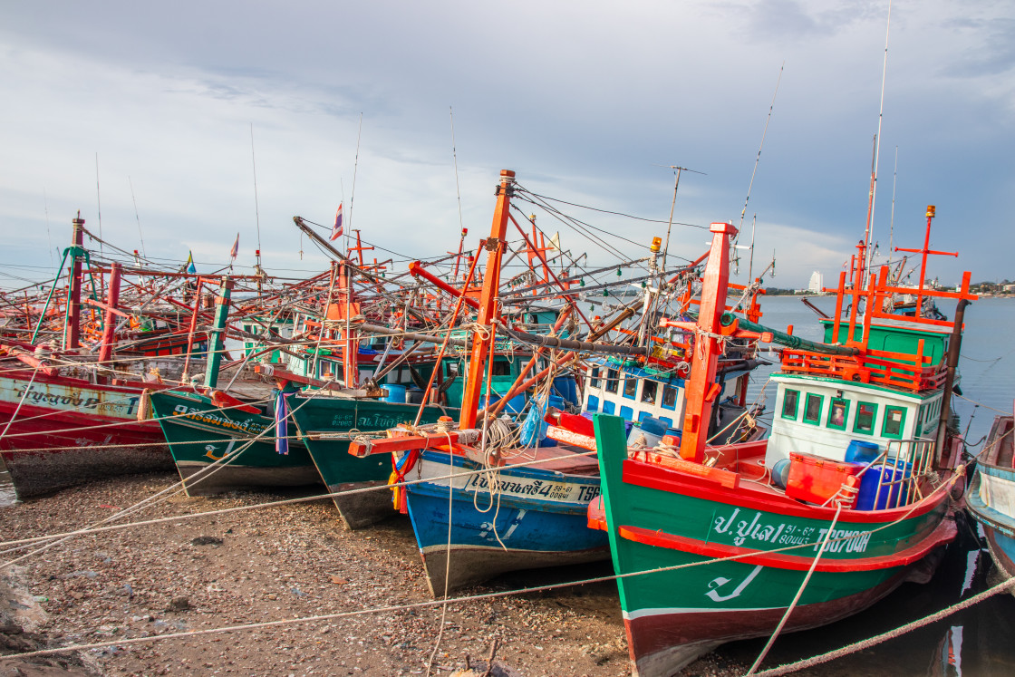 "Thai fishing boats at a pier or wharf in Thailand Southeast Asia" stock image