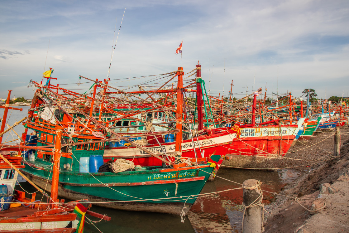 "Thai fishing boats at a pier or wharf in Thailand Southeast Asia" stock image