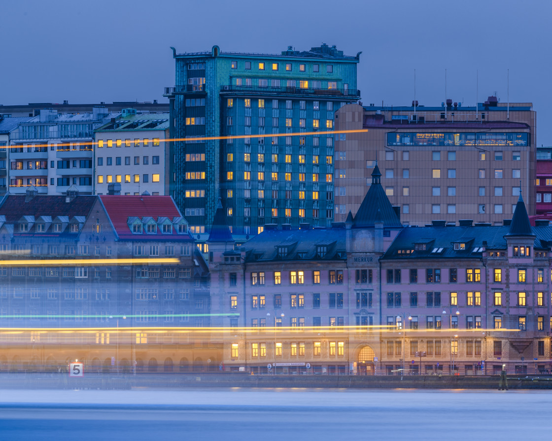 "Ferry passing on river in front of cityscape" stock image