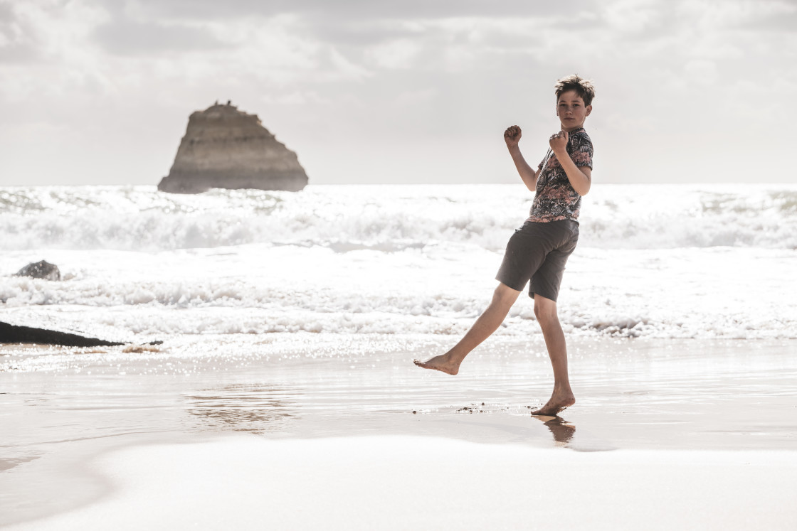 "Boy fooling around on the beach" stock image