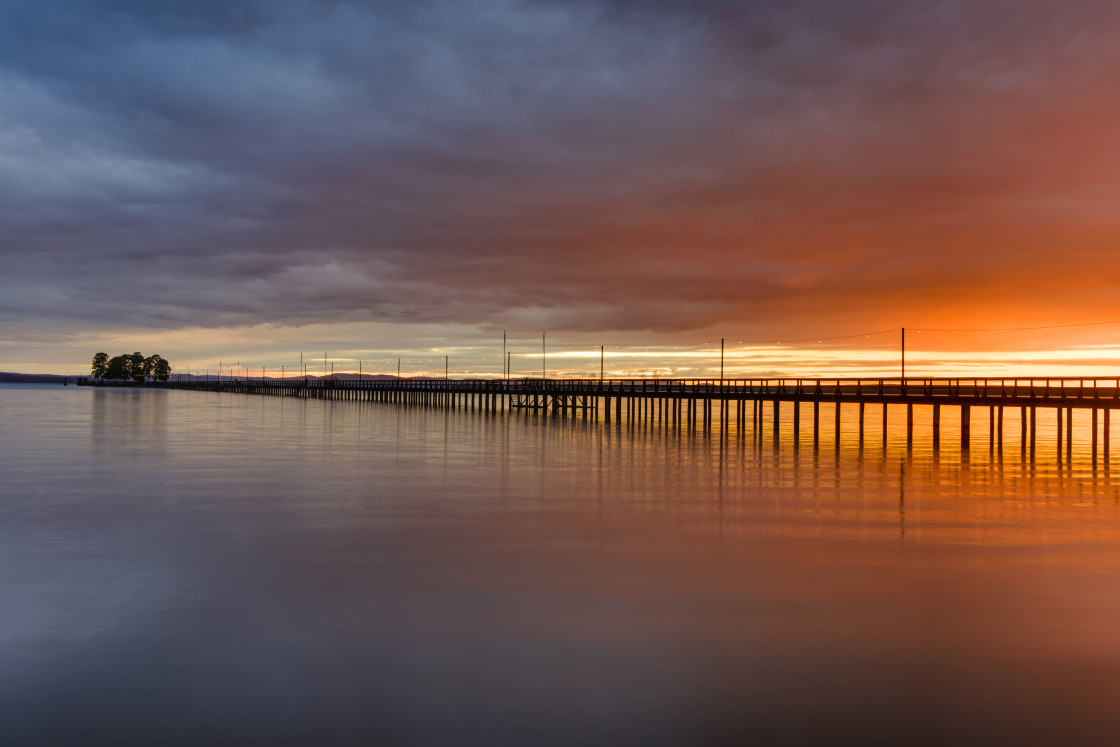 "Pier on lake at sunset" stock image