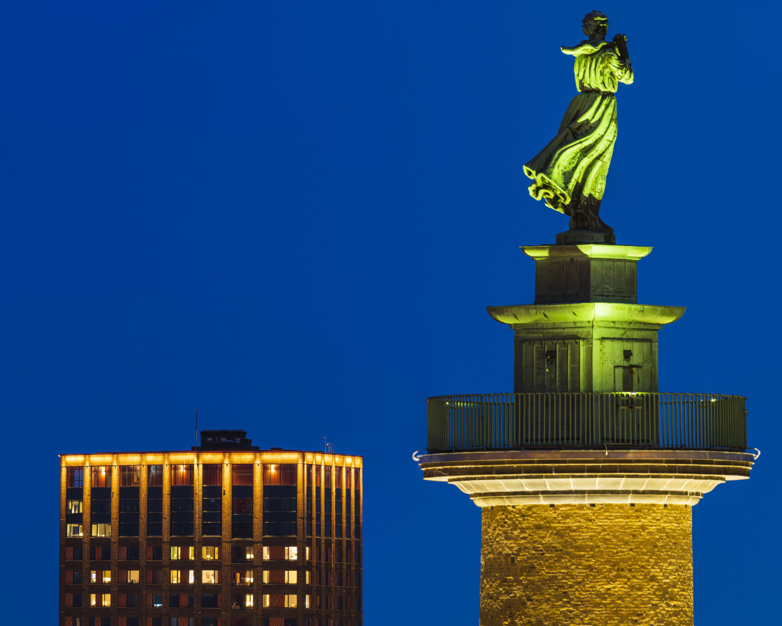 "Illuminated bronze statue of a woman" stock image