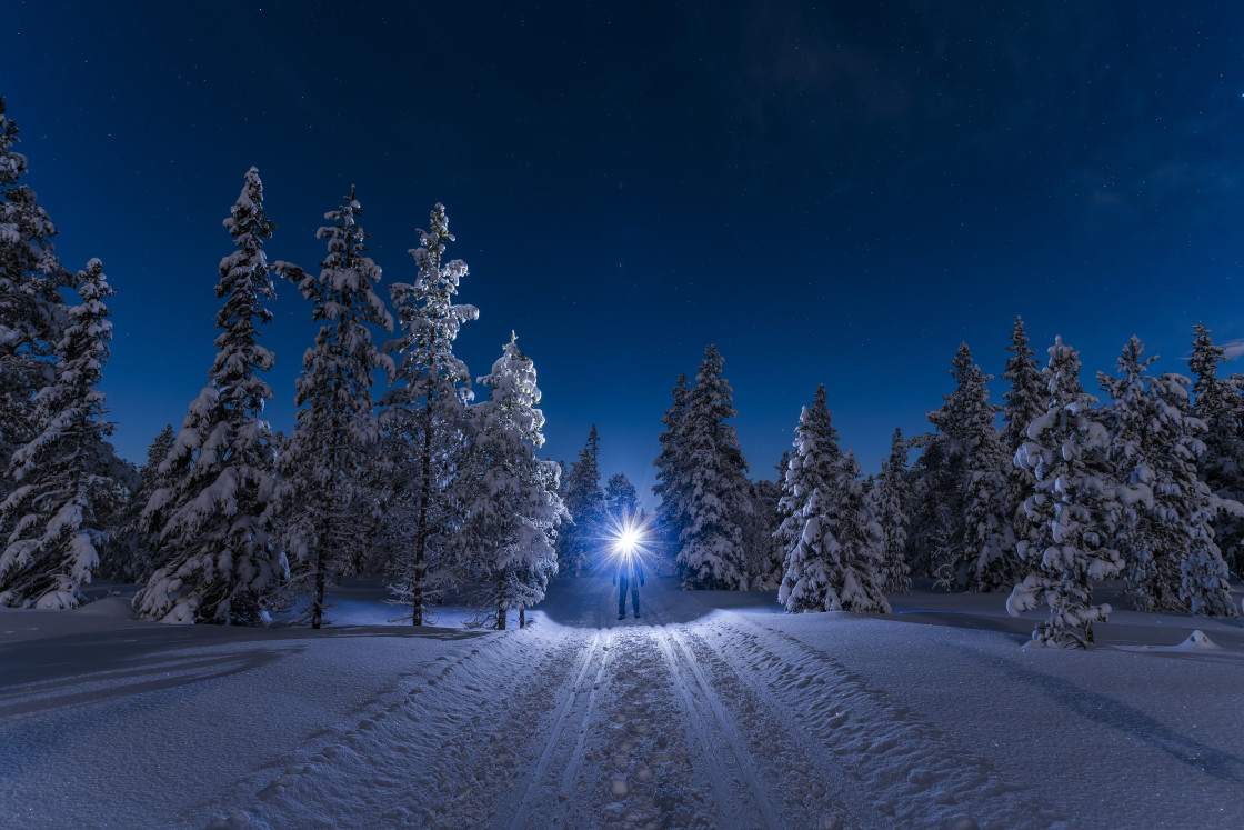 "Man with backpack and headlamp standing under starry sky" stock image