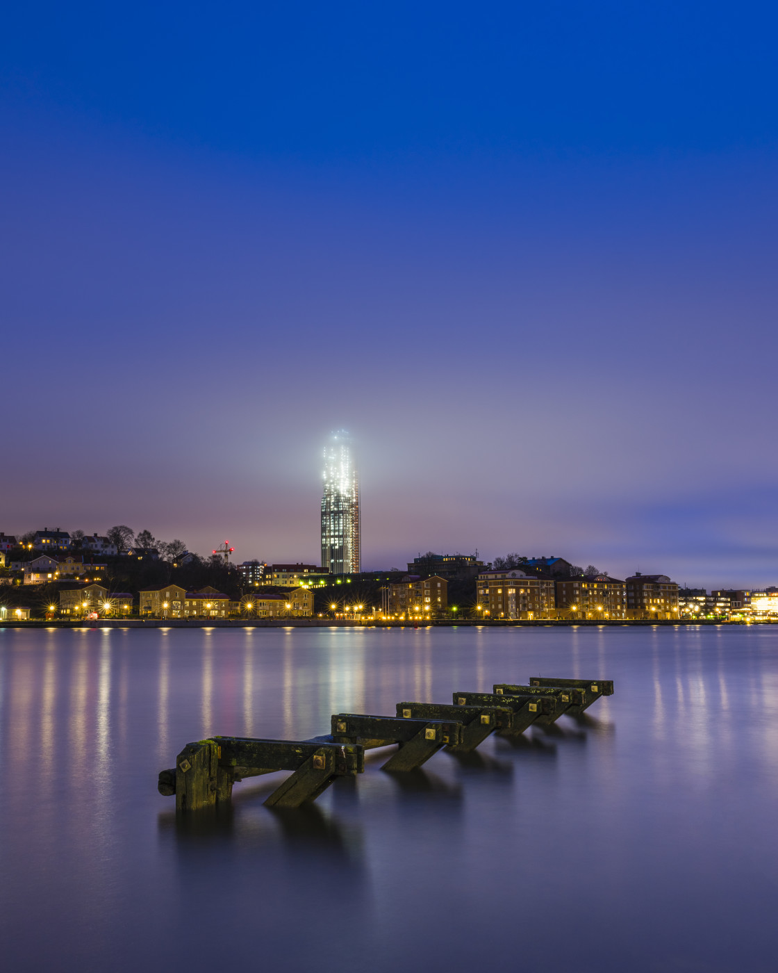 "Wooden structure in river in front of cityscape" stock image