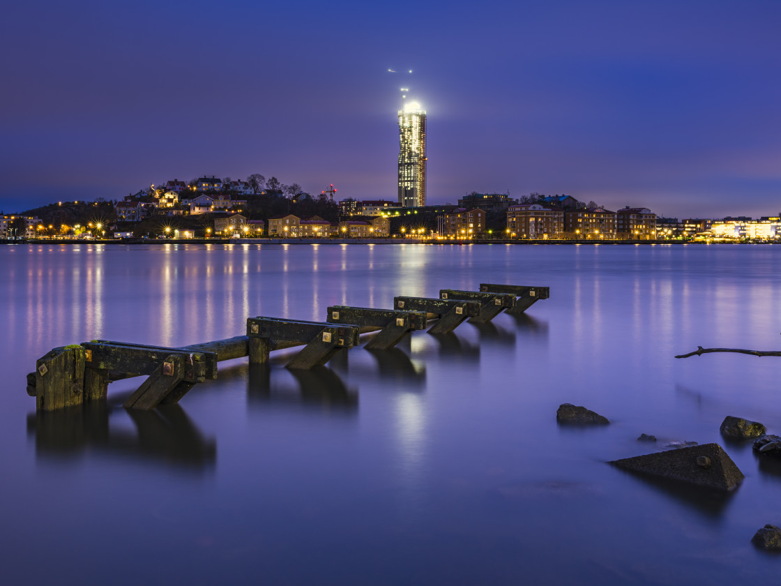 "Wooden structure in river in front of cityscape" stock image