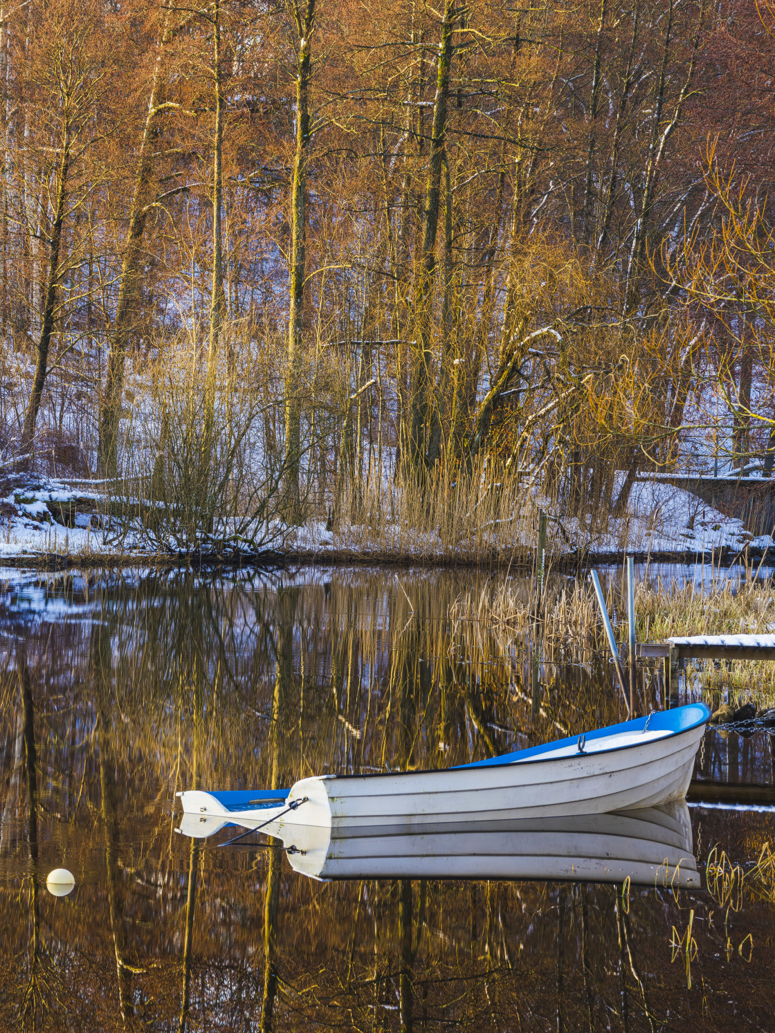 "A tranquil winter scene of a moored boat beside a jetty in nature, with the..." stock image