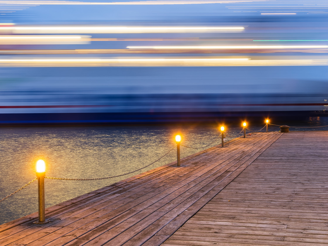 "Long Exposure of a Moving Ship Overlooking a Pier at Twilight" stock image