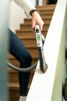 Showing the handle of a Flexit hose kit with LCD display in use indoors