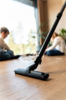 Showing Flexit standard floor nozzle on wooden floor with children playing in the background