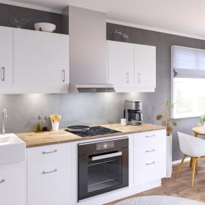 Kjøkken med integrert ventilator i hvite overskap over koketopp
