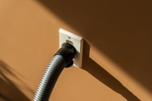 Close-up of a central vacuum hose connected to a Flexit wall inlet valve